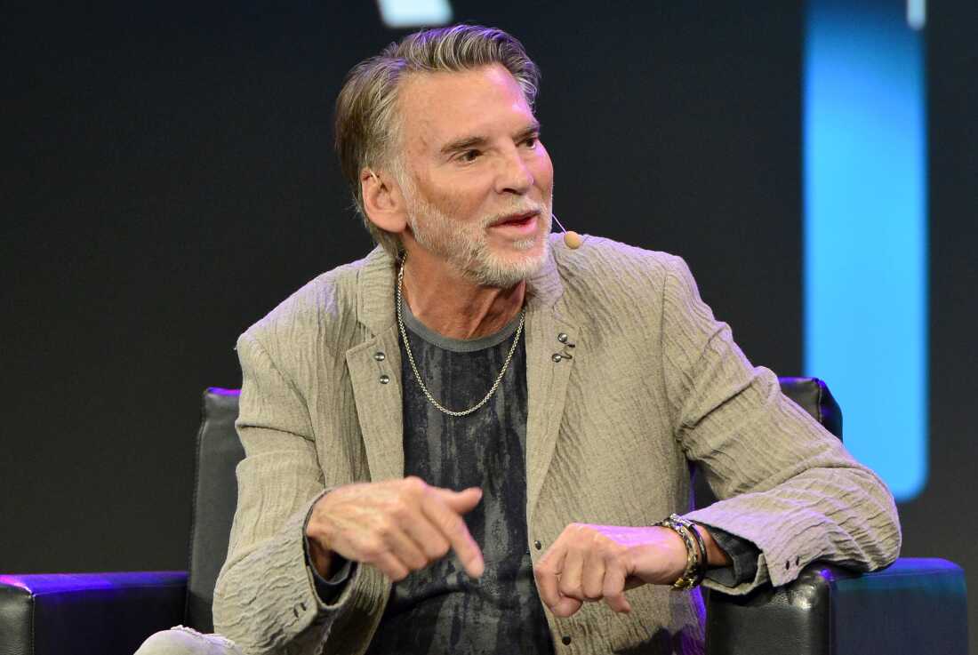 Singer-songwriter Kenny Loggins, seated in an armchair, speaks at the National Association of Music Merchants convention in Anaheim, California, in June 2022.